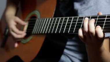 Gitar çalıyorum. Akustik gitar çalan bir genç. Kapatın. Yaşam tarzı kavramı.