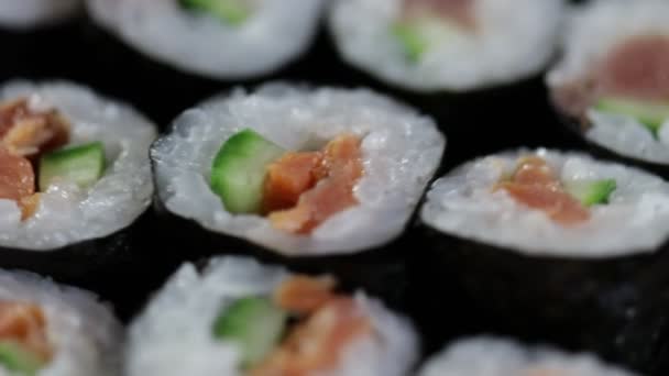 Закройте Роллы Суши Вращающиеся Японская Кухня Авокадо Лосося Тунца — стоковое видео