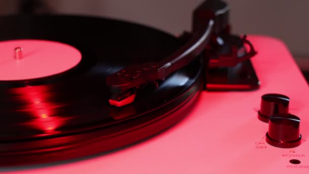 ビニールプレート 赤の色合いとビニールターンテーブル 蓄音機のレコードプレーヤー 音楽を再生するためのレトロなサウンド技術 — ストック動画