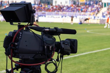 TV camera at the stadium, broadcasting during a football, soccer match