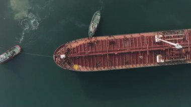 Büyük petrol tankerine yardım eden römorkör görüntüsü. Römorkör eşliğinde büyük bir petrol tankeri limana giriyor..
