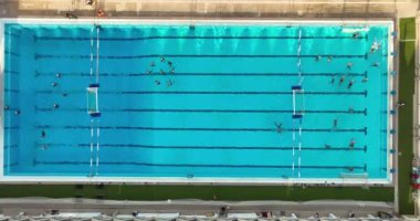 Halka açık yüzme havuzu manzarası. Su topu takımı antrenman yapıyor. Sanatsal yüzme pratiği 