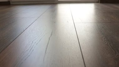 Yeni kaplama döşeme. Kahverengi ahşap desenli işlenmiş parke.