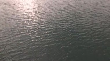 İnsansız hava aracı okyanus ve deniz üzerinde uçuyor. Suya yakın.