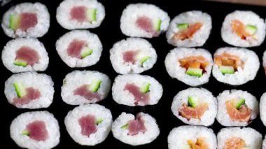 Close up sushi rolls. Japanese food with avocado, salmon, tuna.