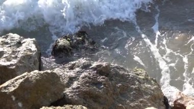 Top down view of waves crushing the coast line, rocks