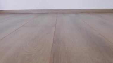 Yeni kaplama döşeme. Kahverengi ahşap desenli işlenmiş parke.