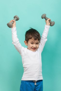 Dumbbells ile sportif küçük çocuk. Sağlıklı bir yaşam tarzı. Spor ve aktiviteler çocuklar için.