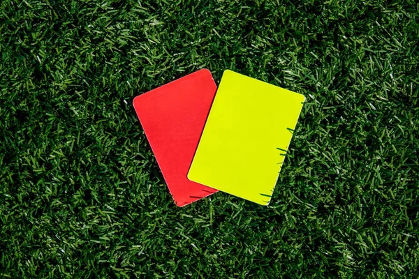 緑の芝生の上でサッカー サッカーゲーム 赤と黄色のカードを参照してください 審判の罰カード二枚 — ストック写真