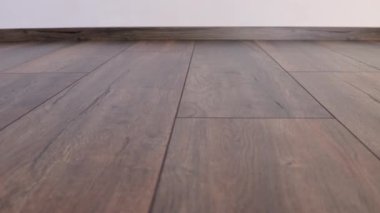 Yeni kaplama döşeme. Kahverengi ahşap desenli işlenmiş parke.