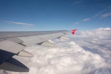 Bulutların üzerinde uçan bir uçağın kanadı. Seyahat kavramı