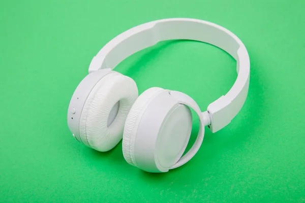 绿色背景的白色无线耳机 音乐概念 绿色背景耳机 — 图库照片