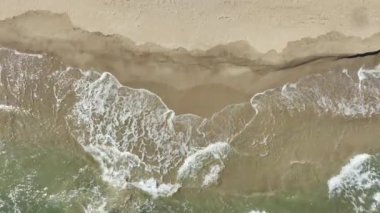 Tropik plaj, köpüklü okyanus dalgaları kum yıkıyor. Dalgalar kumsala vuruyor