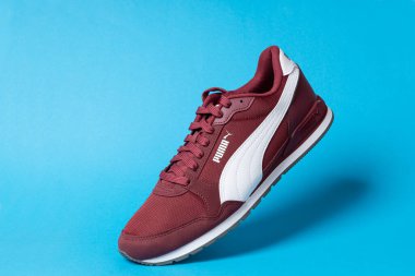 Varna, Bulgaristan - 17 Ocak 2023. PUMA spor ayakkabısı, mavi arka planda. Puma, büyük bir Alman çokuluslu şirketi. Ürün çekimi