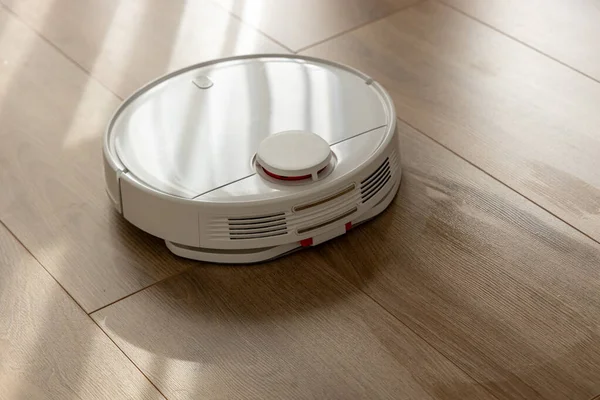 Vacuum Robot cleaning at home. Robot vacuum cleaner in the modern home. Smart cleaning technologyVacuum Robot cleaning at home. Robot vacuum cleaner in the modern home. Smart cleaning technology