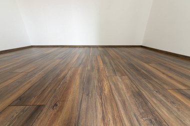 Beyaz duvarlı, kaplamalı ahşap zemin. Yeni dairelerde yüzen kaplamalı boş bir oda.