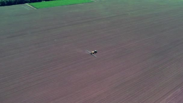耕作拖拉机喷涂在田里的空中景观 保护植物 — 图库视频影像