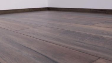 Yeni kaplama döşeme. Kahverengi ahşap desenli işlenmiş parke.