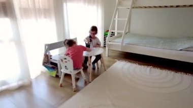 İki küçük kız, evde resim çizen kız kardeşler. Kızlar resim yapmaktan hoşlanır.