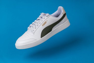 Varna, Bulgaristan - 13 Ekim 2023. Mavi arka planda beyaz PUMA Shuffle spor ayakkabıları. Puma, büyük bir Alman çokuluslu şirketi. Ürün çekimi