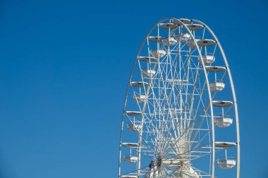 Büyük, uzun beyaz dönme dolap. Modern dönme dolap mavi gökyüzü ile karnavalda