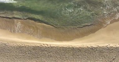 Tropik plaj, köpüklü okyanus dalgaları kum yıkıyor. Dalgalar kumsala vuruyor