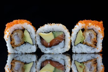 Üç suşi rulosu. Yansımalı suşi. Geleneksel Japon yemekleri.