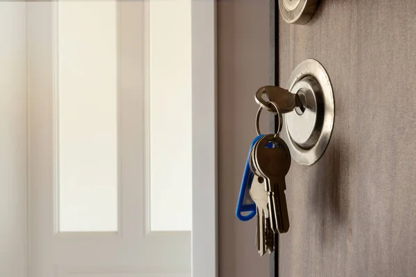 Open door to a new home. Door handle with keys. Mortgage, investment, real estate, property and new home concept