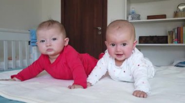 Evdeki yatakta sevimli bebek ikizler. Karnını doyururken tatlı çocuklar. Yatakta iki bebek ikiz.