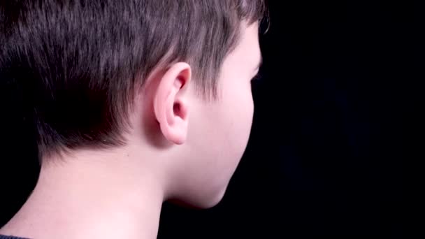 男孩把白色现代无线耳机放在他的耳朵里 无线技术 小男孩用现代耳机听音乐 — 图库视频影像