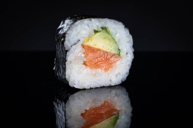 Ton balığı ve avokadoyla suşi rulosu. Yansımalı suşi. Geleneksel Japon yemekleri.