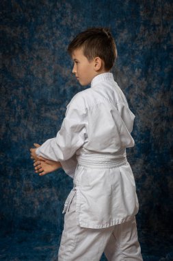 Beyaz kimonolu çocuk dövüş pozisyonunda. Aikdo.