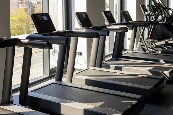 Modern gym interior. Fitness club with row of treadmills for cardio training. Healthy lifestyle concept