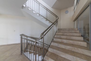 Katlar arasında modern merdiven. Modern binada metal raylı merdivenler