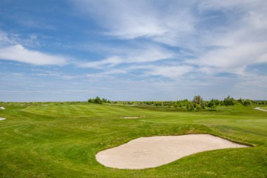 Golf sahası. Yeşil çimen ve bulutlu mavi gökyüzü