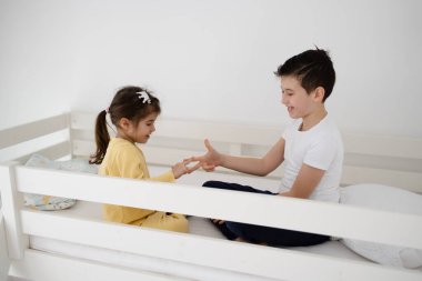 Erkek ve kız kardeş evde taş, makas, kağıt oynuyorlar.