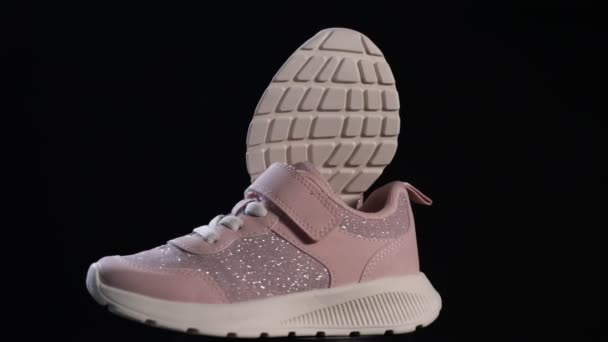粉色运动鞋在黑色的背景上旋转 运动鞋或运动鞋 可爱女孩的鞋子 培训概念 — 图库视频影像