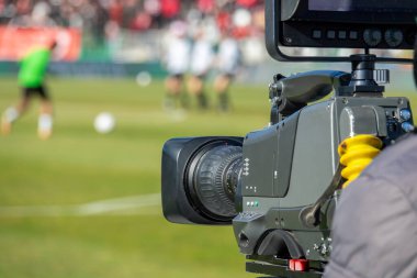 TV camera at the stadium, broadcasting during a football, soccer match