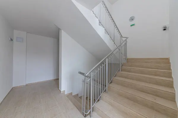楼层之间的现代楼梯 现代建筑中带有金属轨道的楼梯 图库照片