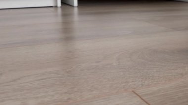 Yeni kaplama döşeme. Kahverengi ahşap desenli işlenmiş parke.