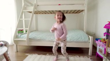 Tatlı küçük kız dans ediyor ve evde eğleniyor.