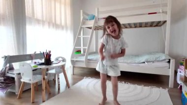 Tatlı küçük kız dans ediyor ve evde eğleniyor.