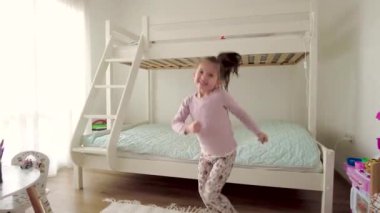 Tatlı küçük kız dans ediyor ve evde eğleniyor.