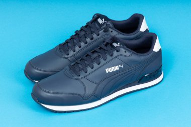 Varna, Bulgaristan - 12 Ekim 2019 PUMA RUNMA V2 Full Leather spor ayakkabıları mavi arka planda. Puma bir Alman şirketi. PUMA dünyanın en büyük üçüncü spor giyim üreticisi. Ürün çekimi