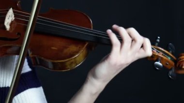Kızlar keman çalar. Keman çalan ellerin yakın çekimi. Kadın, keman müzisyeni, çalıyor.