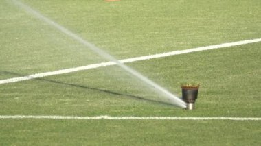 Yağmurlama sistemi üzerinde taze yeşil çim futbol Stadı üzerinde çalışan