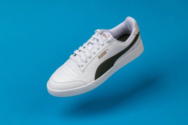 Varna, Bulgaristan - 13 Ekim 2023. Mavi arka planda beyaz PUMA Shuffle spor ayakkabıları. Puma, büyük bir Alman çokuluslu şirketi. Ürün çekimi