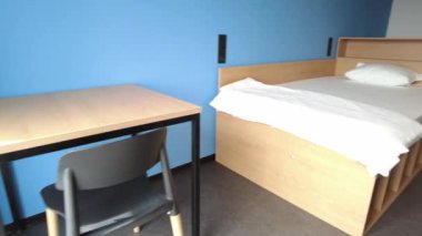 Simple student-style dorm bedroom. Hostel dormitory room. Campus