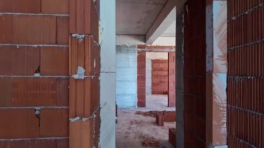 İnşaat halindeki evin içinde tamamlanmamış bir oda. Tuğla kırmızı duvarlar. Yeni ev.