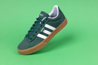 Varna, Bulgaristan - 21 AĞUSTOS 2024: Yeşil arka plan çekimleri için ADIDAS günlük spor ayakkabısı 3.0. Adidas spor ayakkabıları, giysileri ve aksesuarları tasarlayan ve üreten bir Alman şirketidir.